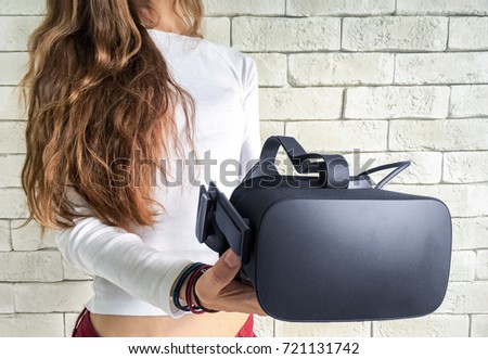 Beautiful young woman holding virtual reality headset