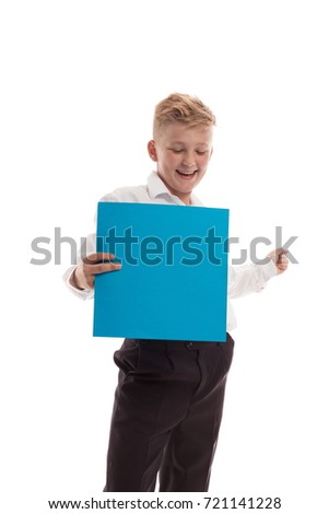 Emotional blond boy in striped sport shirt holding a blue sheet of paper for notes, posing on white background