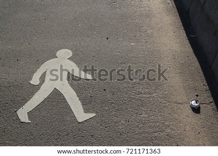 The sign of the walking person (pedestrian) is striving to raise the empty can thrown by the man. Concept: man and garbage, vice and overcoming of shortcomings.