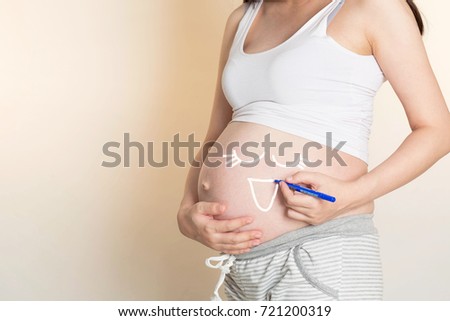 Happy pregnant woman draw cute cartoon on tummy her and touching her belly at home, Concept of pregnant women healthy and  Maternity concept 