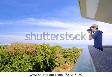 Tourist attraction. Traveler taking photo with camera on the view point enjoying sea, city and sky.