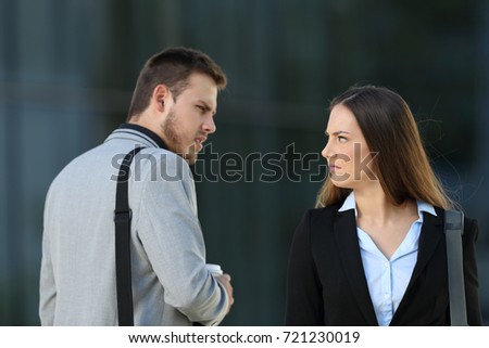 Two envious business competitors meeting and looking each other with hate on the street Royalty-Free Stock Photo #721230019