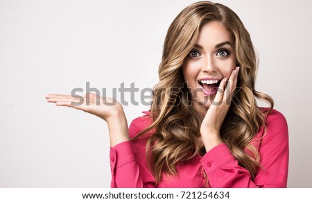 Woman surprise showing product .Beautiful girl  pointing to the side . Presenting your product. Expressive facial expressions emotions  businesswoman
,
 Royalty-Free Stock Photo #721254634