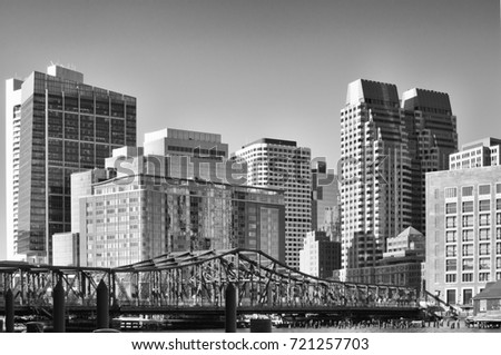 Old closed footbridge to boston seaport district and a view of the financial district buildings skyline black and white