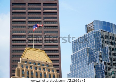 Close up on downtown office building with USA flag waving on top