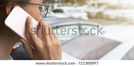 People Asian,Woman wearing glasses use smart phone at blurred parking with car background