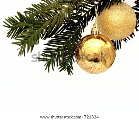 Two gold Christmas decorative balls hanging from a tree