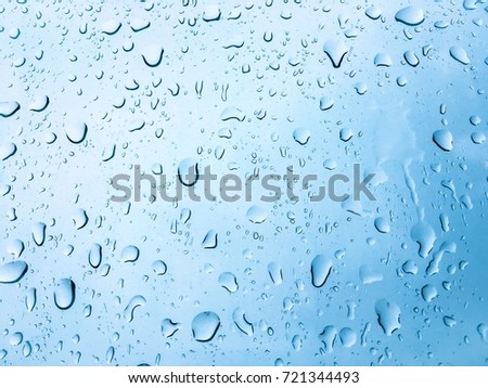 Water drop on the glass after rain with a colored background