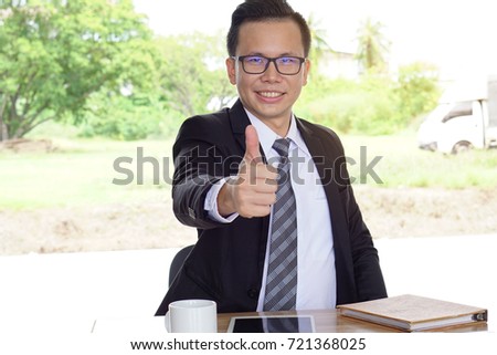 Businessman showing thump up with smiling