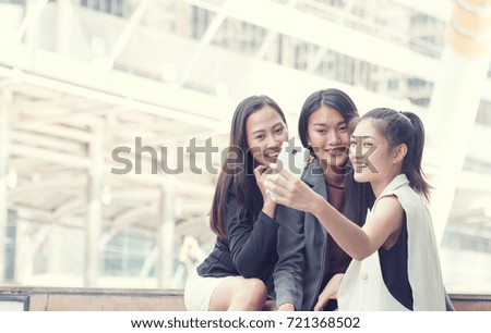 Businesswoman with smartphone and pointing at screen surprised