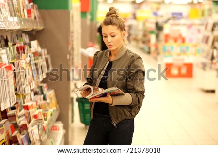Woman holding magazine,buying a book in a store