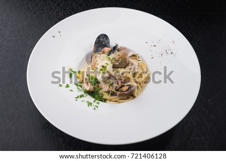 seafood pasta with squid and mussels in a white plate. dish at the restaurant