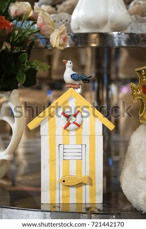 Beach changing room. Wooden miniature of a vintage beach toilet in stripe yellow and white for interior decoration of home decor, beach vacation concept.
