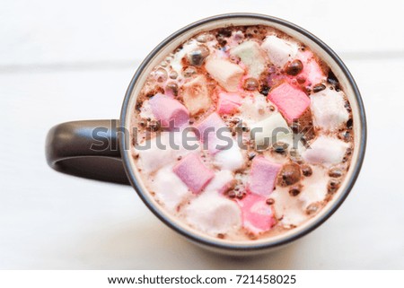 Hot chocolate mug  with colorful  marshmallow on white rustic wooden table. Winter  Christmas cozy home concept