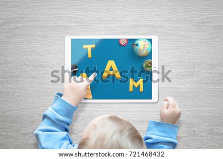 The boy teaches letters and numbers through playing games on the tablet.