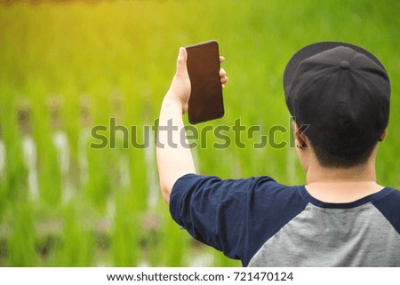 people holding smartphone with nature background. subject is blurred.