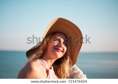 Young woman in straw hat on holidays, sunny day, sea view.