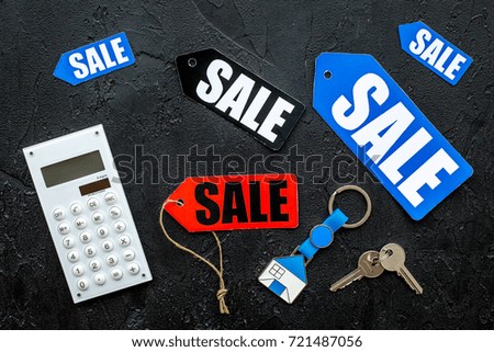 Count the benefits from the sale. Word sale on colored labels near calculator on black background top view
