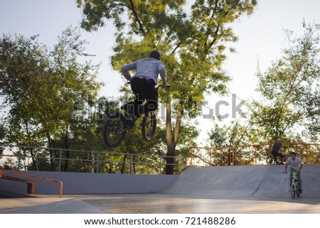 BMX rider training and do tricks in street plaza, bicycle stunt rider in cocncrete skatepark 