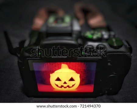Smiley Happy Pumpkin Halloween face on camera screen background blur