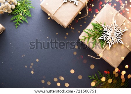 Christmas handmade gift boxes craft paper decorated on dark background top view. Merry christmas greeting card, frame. Winter xmas holiday theme. Happy New Year. Flat lay. Twinkle glitter bokeh light