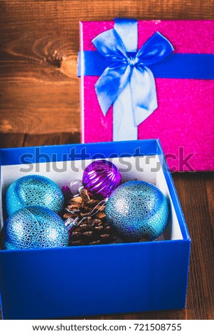 Box with Christmas toys on a wooden background.