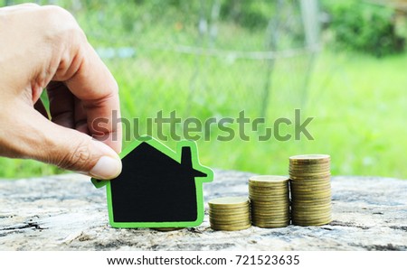 Hand keep and putting house sign with money coins stack for mortgage loan concept backgrounds
