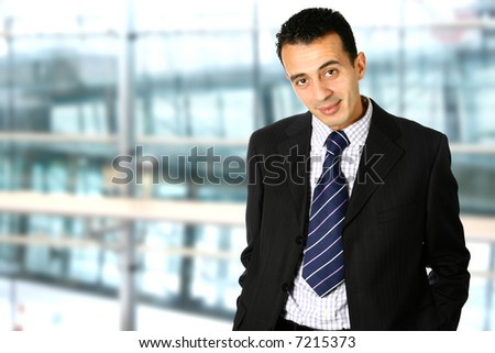 Confident young businessman in corporate interior with copyspace