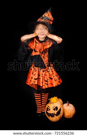 child in halloween costume of witch with jack o lanterns, isolated on black 