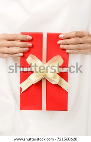 red gift with a bow in the female hands