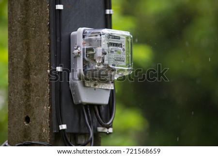Electric meter  box is on the electric pole to measure how much we use electric in each houses
