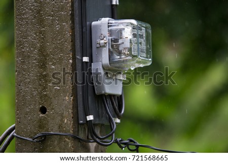 Electric meter  box is on the electric pole to measure how much we use electric in each houses