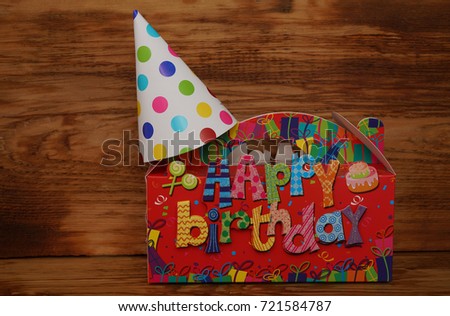 Birthday box, gift.space for text and party hat on turquoise background. Happy birthday template with gift boxes and party hats cake and lights on wooden background