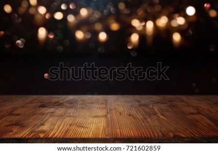 Background with golden bokeh and a empty wooden table  for a christmas decoration