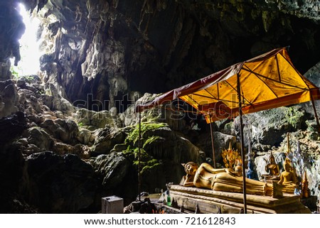 the Light through the hole into the cave, it make a light shine on statue of buddha in the cave on the mountain of Vang Vieng area, Vang Vieng, Laos