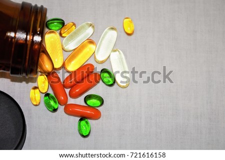 Top view many capsules of vitamins and supplements on white background with a brown bottle. Vitamin c, vitamin E, vitamin D3, salmon oil, fish oil, co enzyme Q10. Vitamin and supplement.