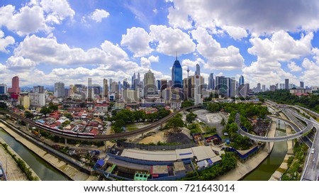 Panorama view of Kuala Lumpur city skyline with dramatic cloud formation and blue sky