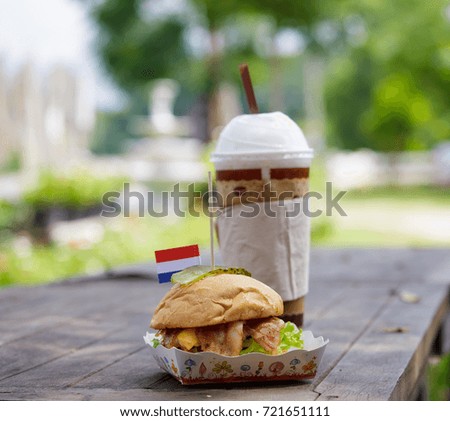 burger with cold coffee on the wood table