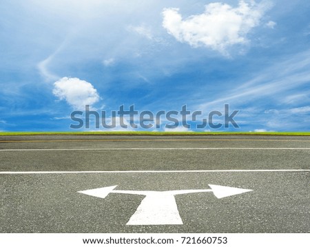 white arrow sign on asphalt road for traffic drive, on cloudy sky background, making choices business concept.
