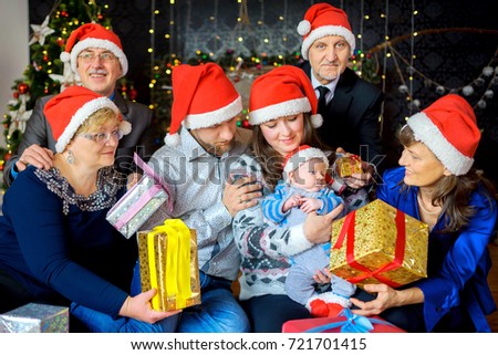a big friendly family celebrates Christmas, gives gifts to the kid and has fun