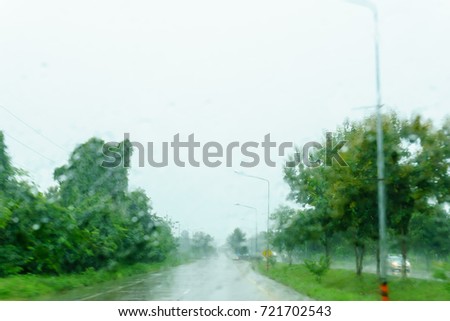 blurred beautiful drop of rain on glass or windows surface with road background. blurred dew or raindrop on glass surface for abstract background