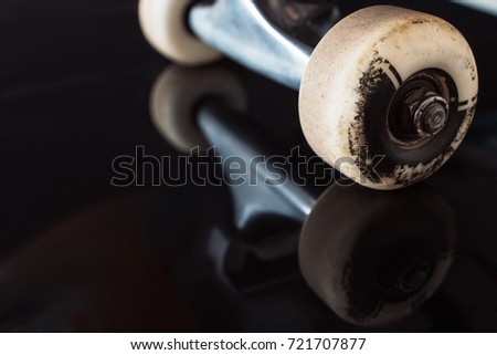 Skateboard truck and wheels on black glance background. Professional extreme sport devices and fastness to rubbing skateboarding elements, close up picture, free space