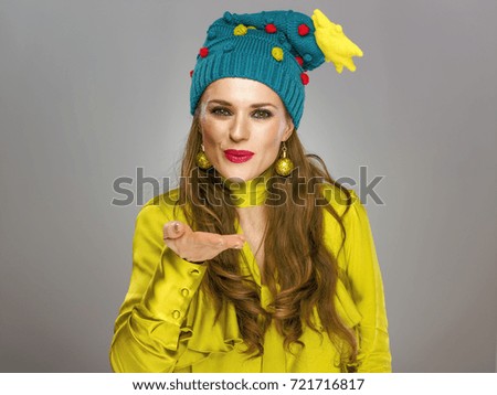 Stunning season. smiling young woman in funny Christmas hat isolated on grey background blowing air kiss