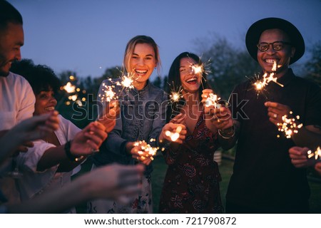 Group of friends enjoying out with sparklers. Young men and women enjoying with fireworks. Royalty-Free Stock Photo #721790872