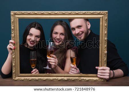 Friendship celebration. Happy portrait photoshoot. Birthday party with champagne, live picture in rectangle frame. Joyful smiling company on blue background, happiness concept
