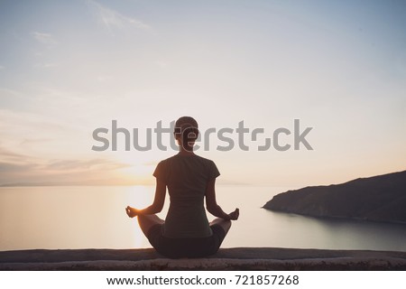 Young woman practicing yoga outdoors. Harmony, self care, relaxation exercises,  healthy lifestyle and meditation concept. Royalty-Free Stock Photo #721857268