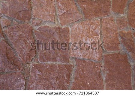 Textured background of an uneven different stone tile wall or a road terracotta color. Space for text