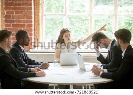 Strict female boss telling upset male employee to leave meeting room during briefing, pointing her finger to the way out. Executive team member scold colleague, CEO firing coworker in front of team.  Royalty-Free Stock Photo #721868521