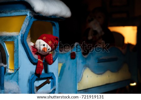 A little boy is riding on a New Year's train