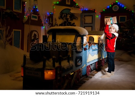 A little boy is riding on a New Year's train